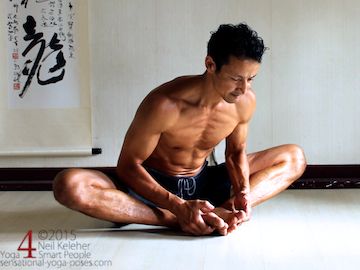 Hip Routine Bound Angle 7 yoga for flexibility, bound angle inner thigh stretch (baddha konasana) with a 45 degree forward bend, hands grabbing the feet. Make the spine feel long from pelvis to head, push the feet into the floor and use the arms to pull up on the feet so that the ribcage moves down. In this picture my elbows point back. Model, Neil Keleher. Sensational Yoga Poses.